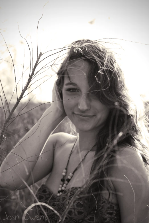 a woman is standing in tall grass with her hands on her head