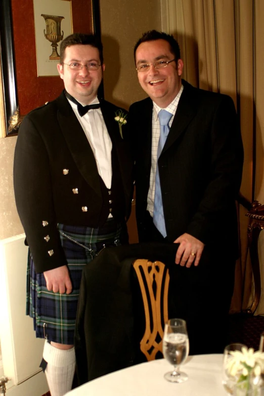 two men are standing by a table at a dinner