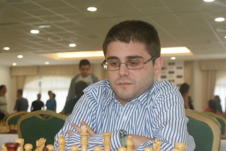 a man sits playing a chess game with pieces