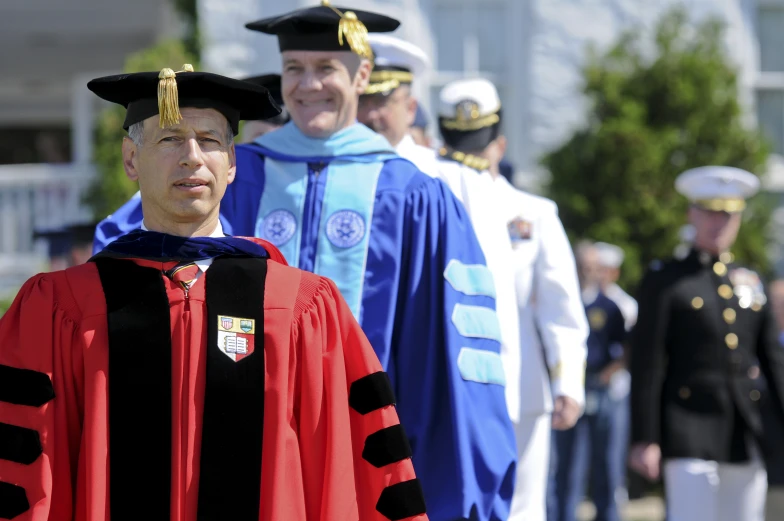 the two graduates smile as they walk towards the ceremony