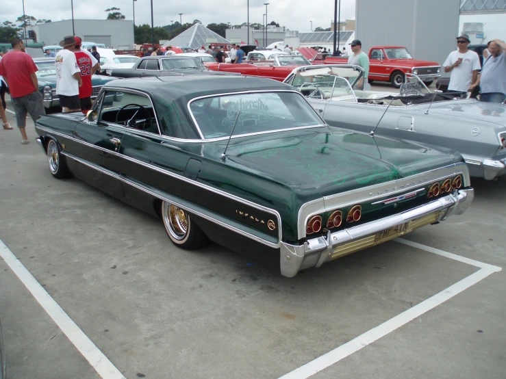 a black and green classic car on display in a parking lot