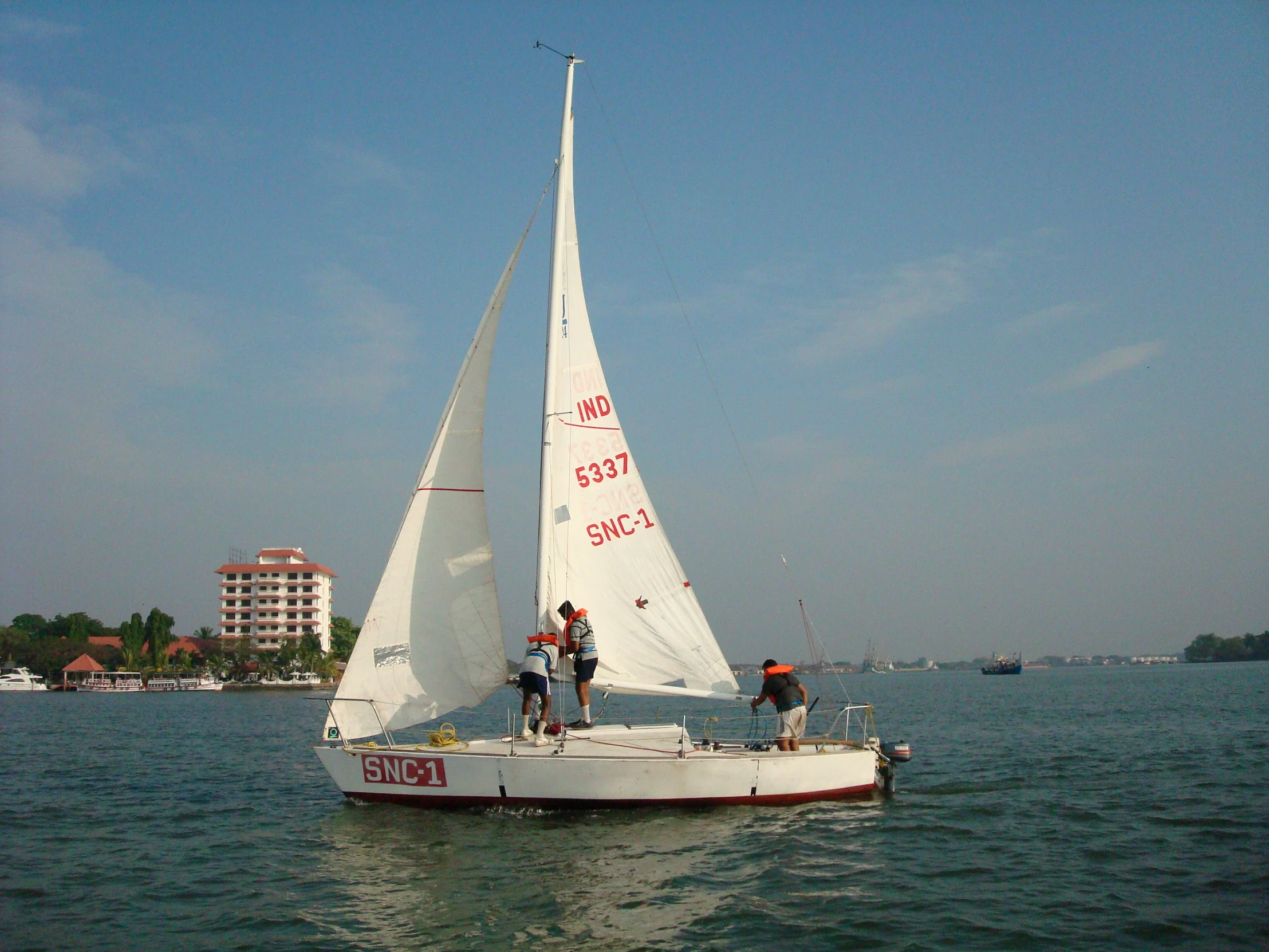 people standing on a sail boat in the water