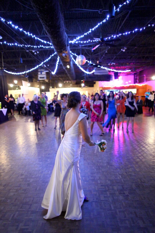 a bride and groom dance in a large ballroom