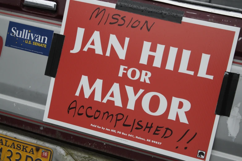 a sign reading, jan hill for mayor accomplishied, on the back of a car