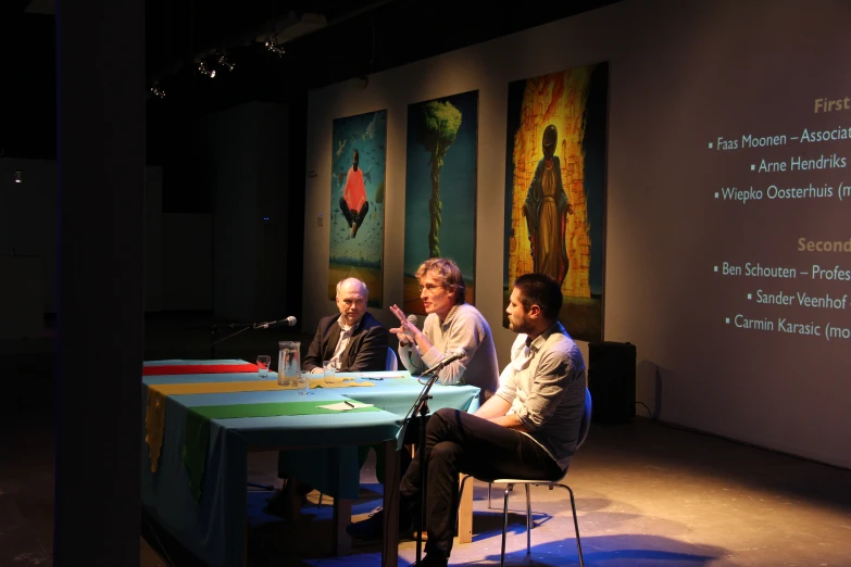 three people are sitting down at a table