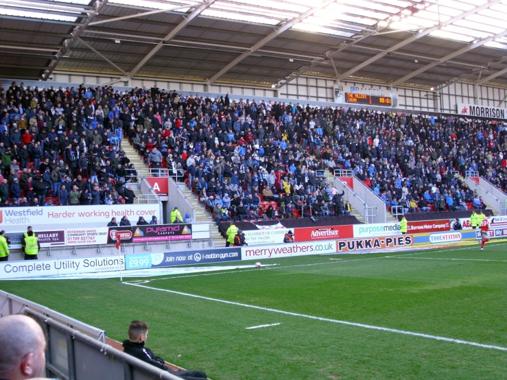 many people sitting in the stands watching a soccer game