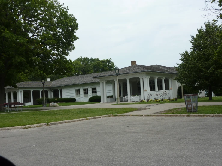 a white building with a black roof near trees