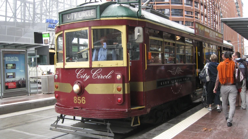 people walking and waiting for the trolley train to pass them