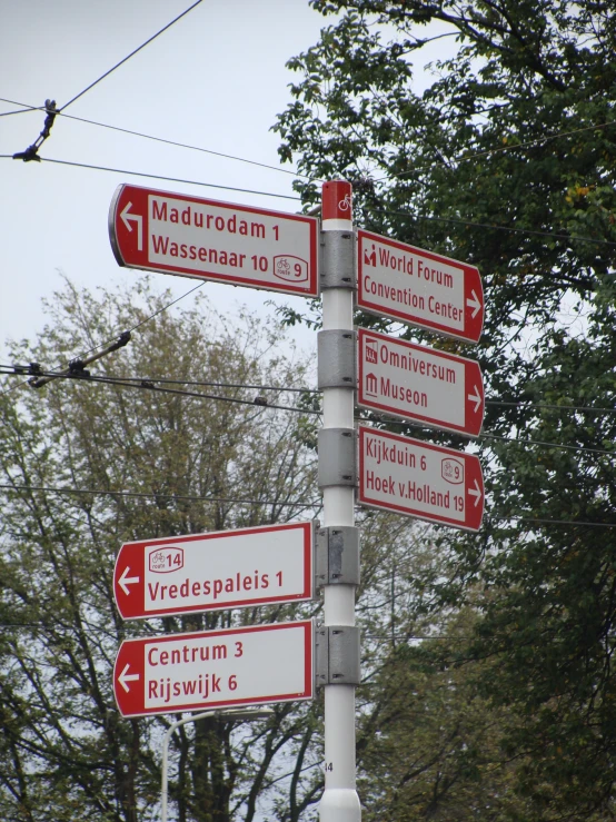 a pole with many street signs mounted on it