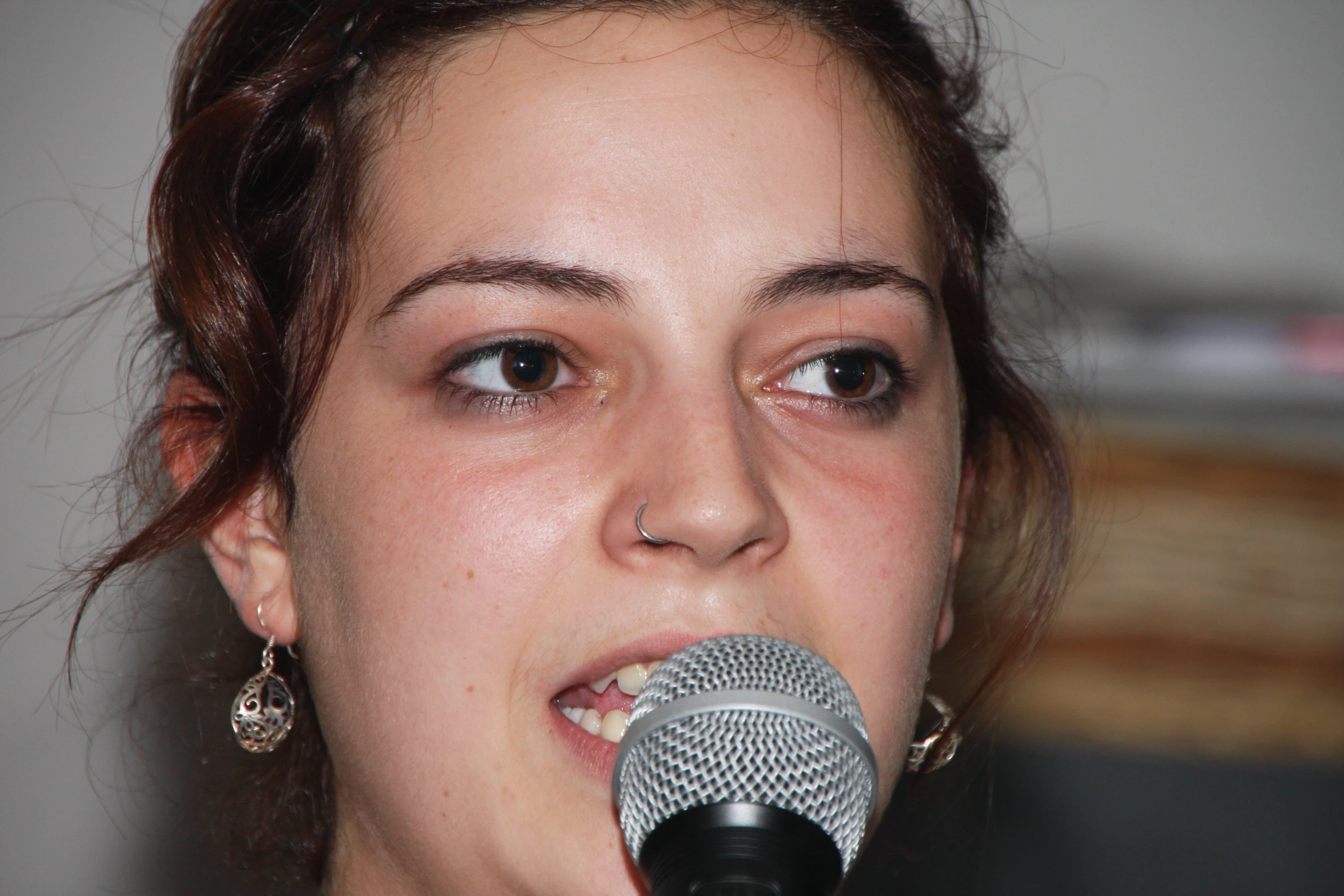 a close - up view of a girl singing on stage