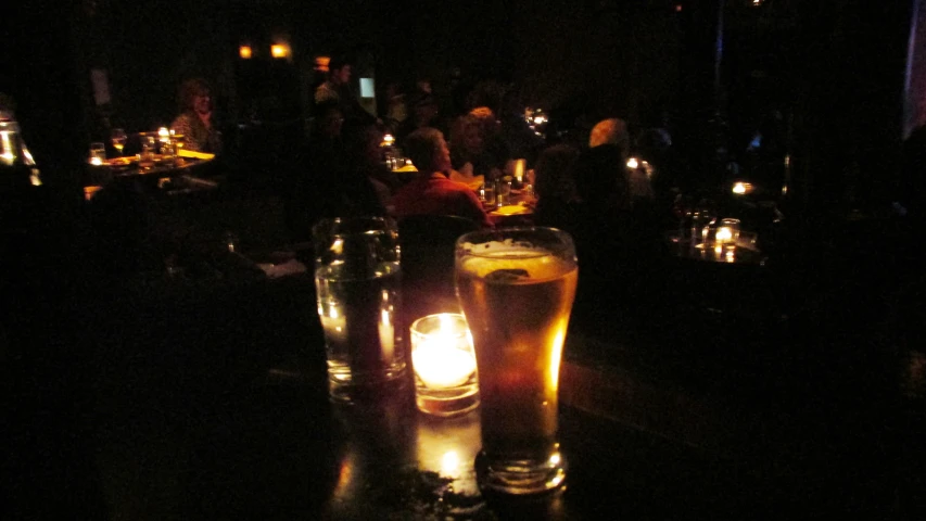 a dark room with a group of people and candles