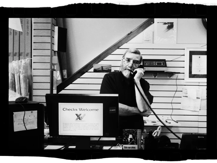 a man sits in an office and talks on the phone