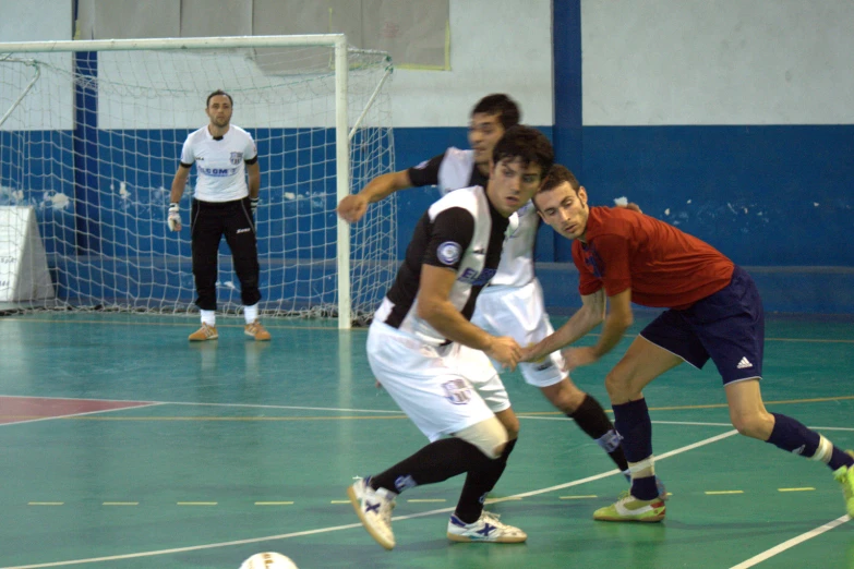 two soccer teams trying to kick a ball