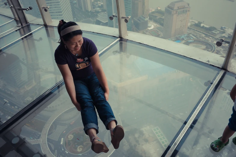 two people hang - gliding along the glass walkway that has a view