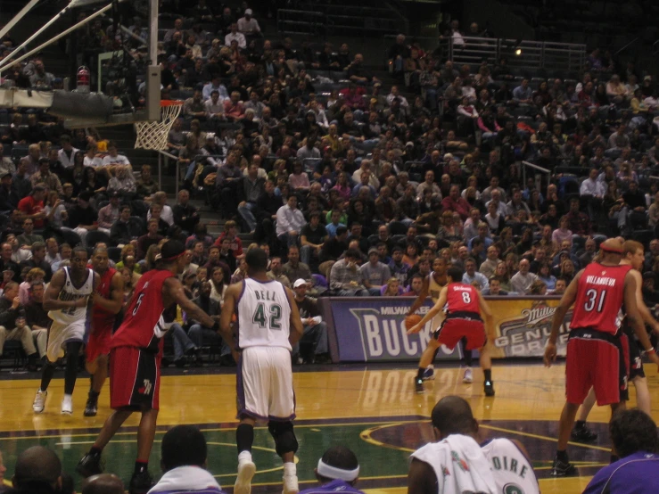 a group of men playing basketball against each other