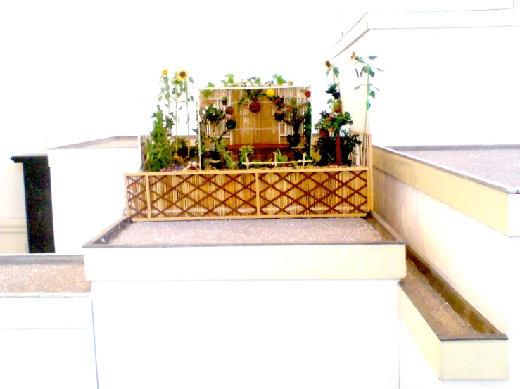 a wooden crate containing plants and flowers on top of a stair case