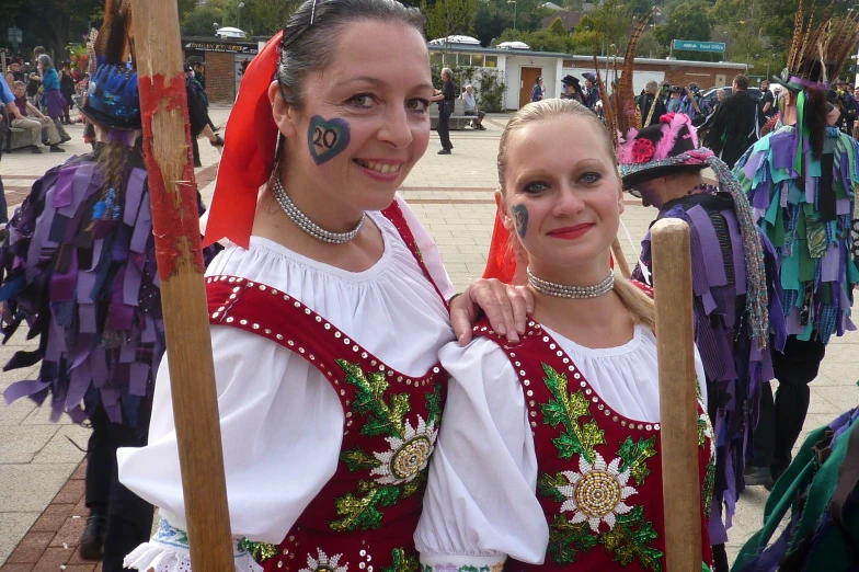 two woman with painted face paint pose for a po
