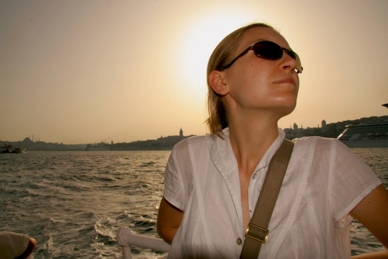 a person on a boat in a body of water at sunset