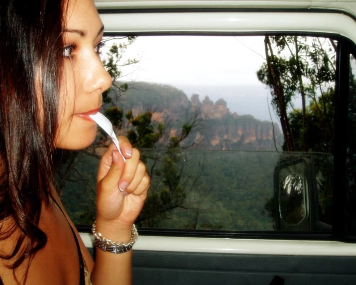 the young woman is staring out the window at the mountains