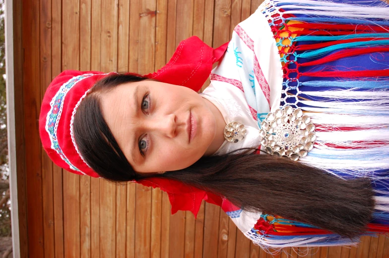 a woman wearing an indian outfit stands by the fence