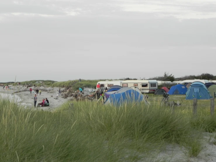 a group of tents and people in grassy area