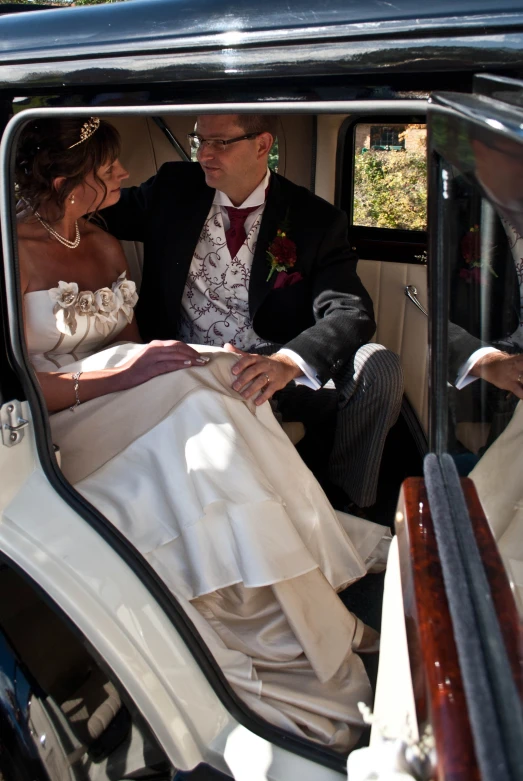 bride and groom in a vintage car with bride looking out of window