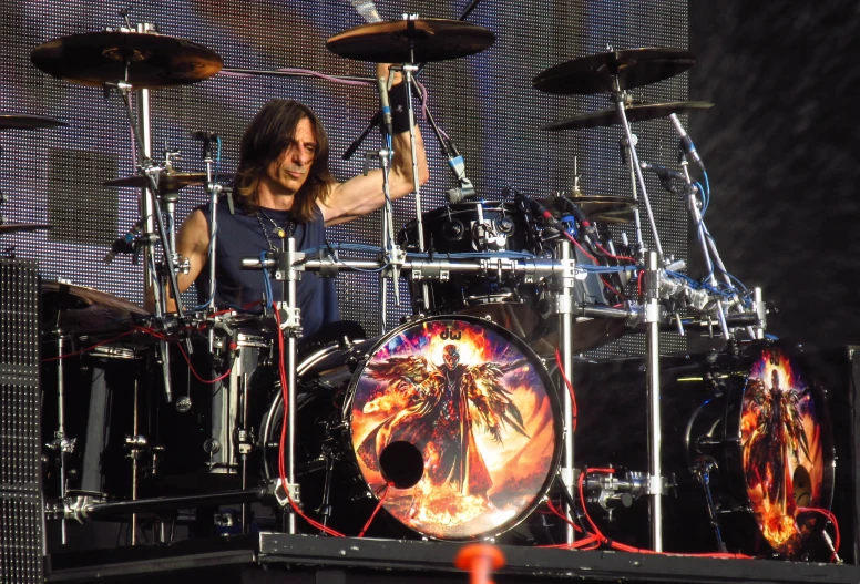 a man playing drums on stage in front of a set of drums