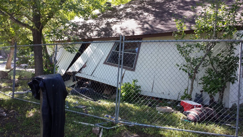 a home is behind a fence with a fire hydrant in the front yard