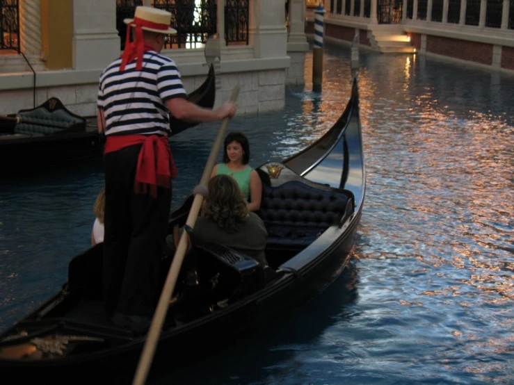 a man and woman are riding a gondola in a canal