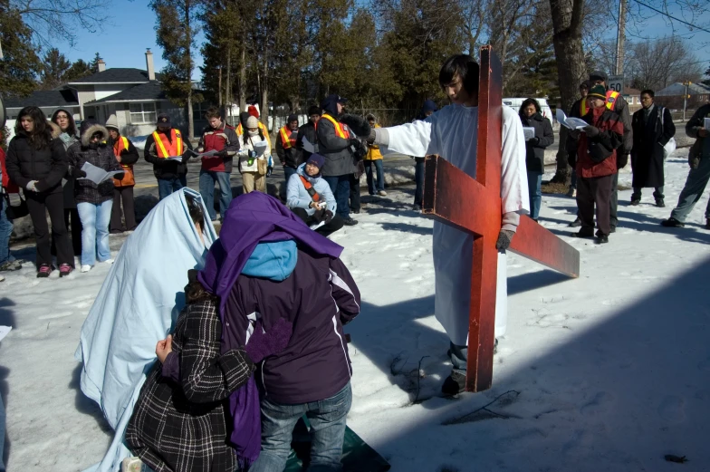 a crowd of people standing next to a cross and holding onto soing