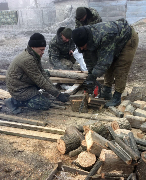 soldiers are assembling logs in a field