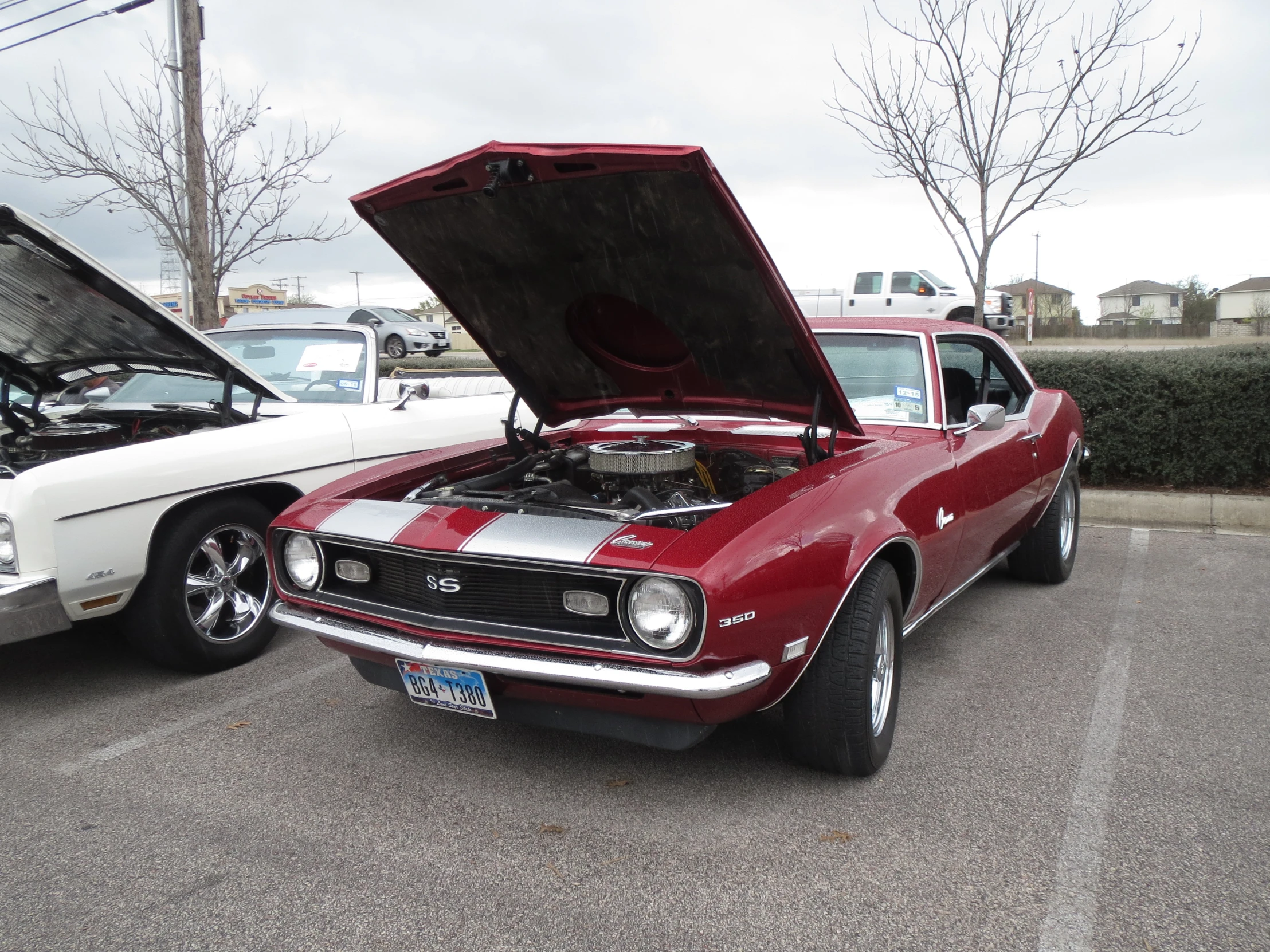 there is a old muscle car and a older one in the parking lot