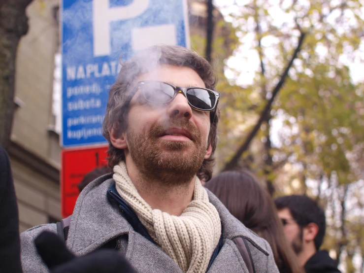 a man smoking a cigarette in front of people