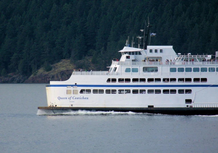 a large white boat is going across a body of water