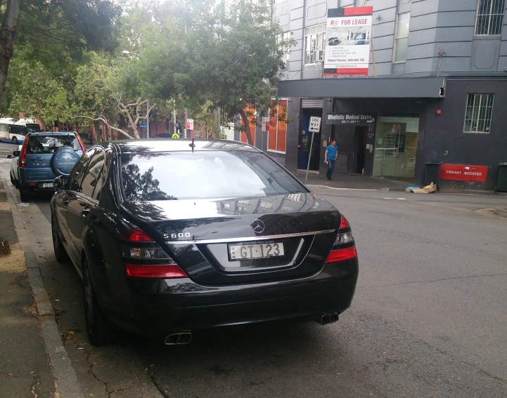 a black sedan that is parked on the side of a road