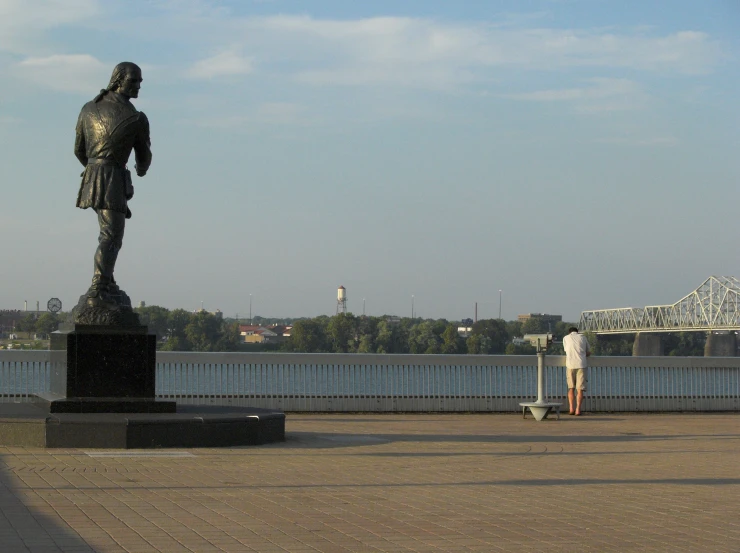 a person standing next to a large statue in a park