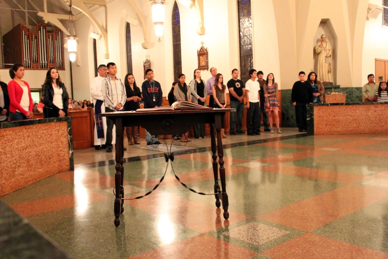people standing and sitting at a podium in a church