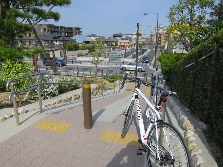 a bicycle leaning on a railing with a street scene in the background