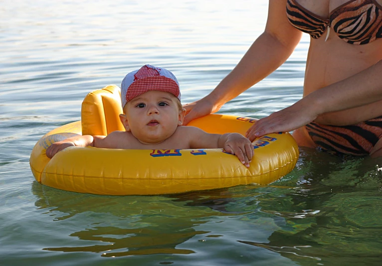 a woman is showing a small boy how to float