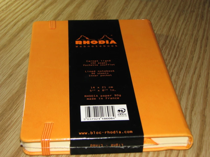 an orange book sitting on top of a wooden table