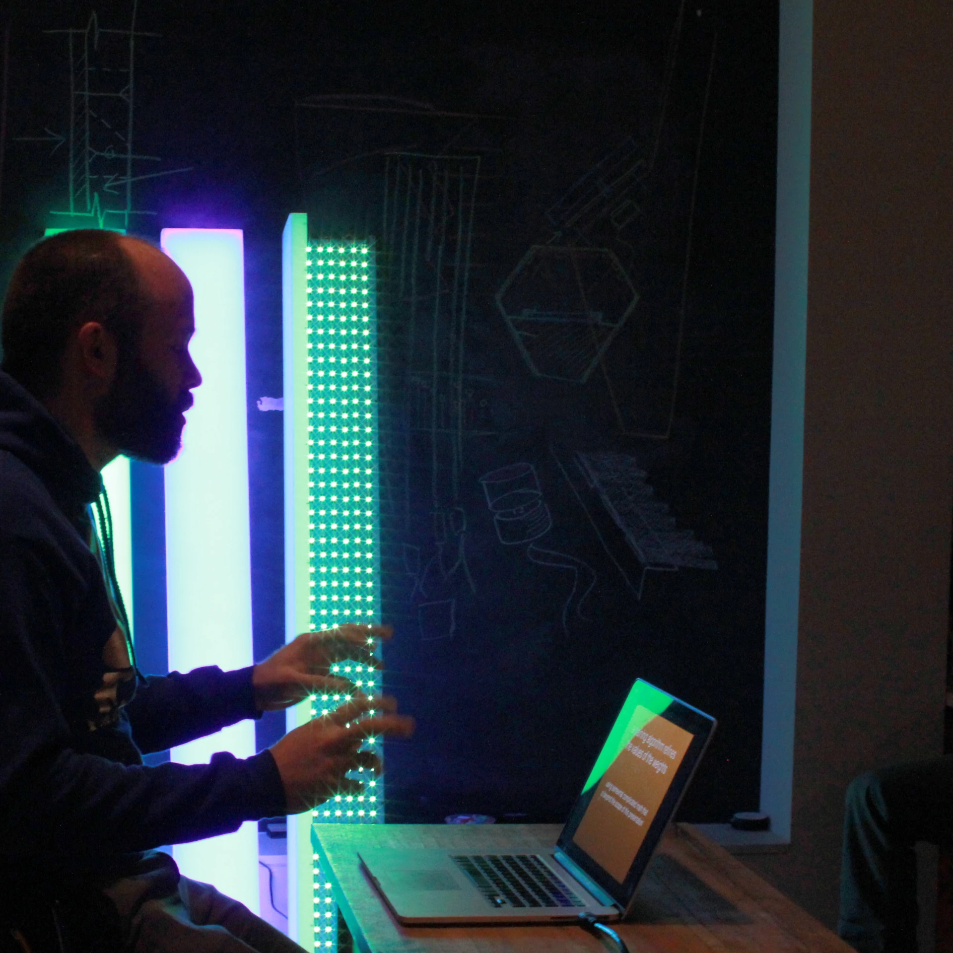 man at a table in front of an illuminated laptop