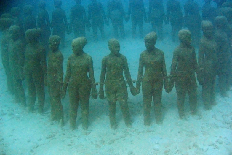 several large,  sculptures surrounded by sand