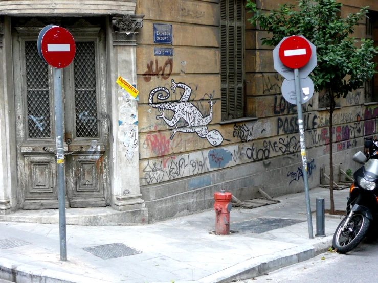 a motorcycle parked next to two red signs and pole with stickers on them