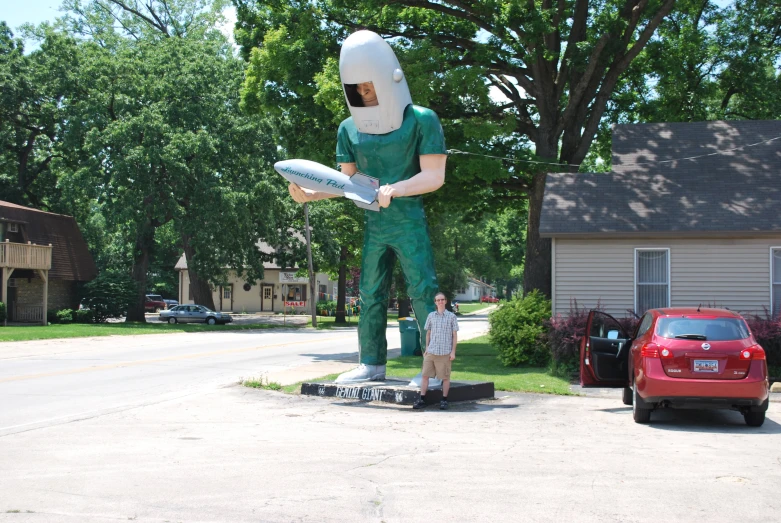 a man in green costume holding an object in a field