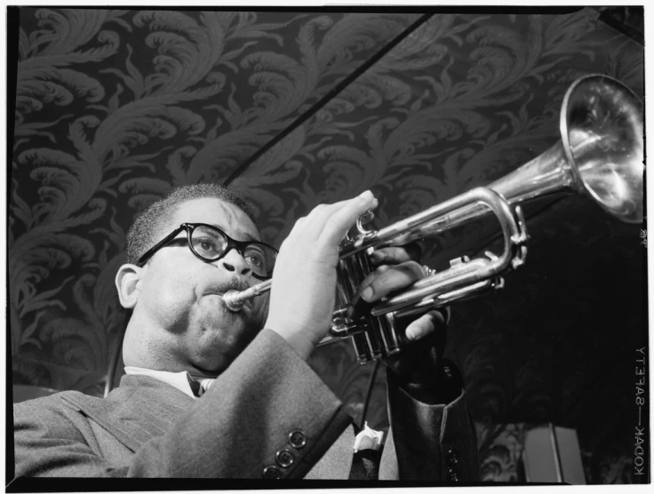 a man in glasses playing a trumpet