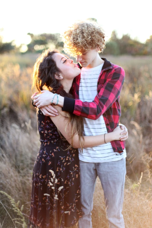 a woman gets comforter from a man in an empty field