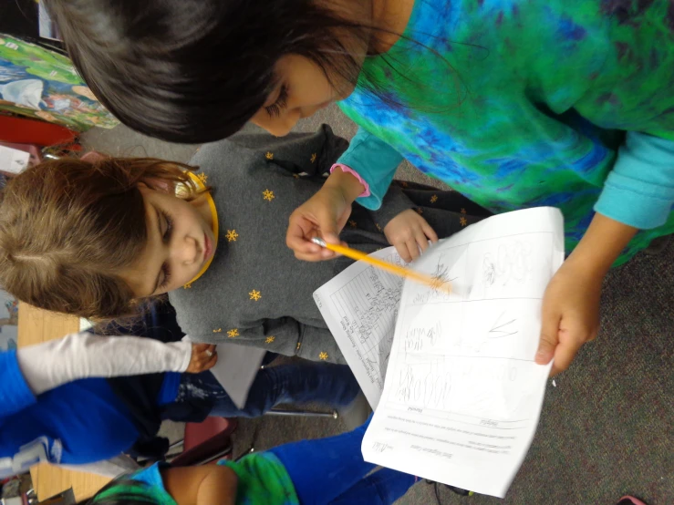 two little girls holding soing with a pencil in their hand