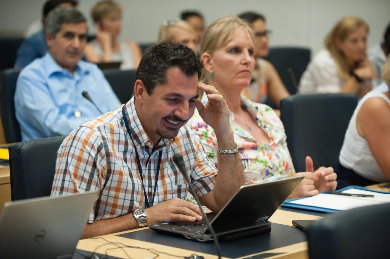 a group of people sitting at desks using laptops