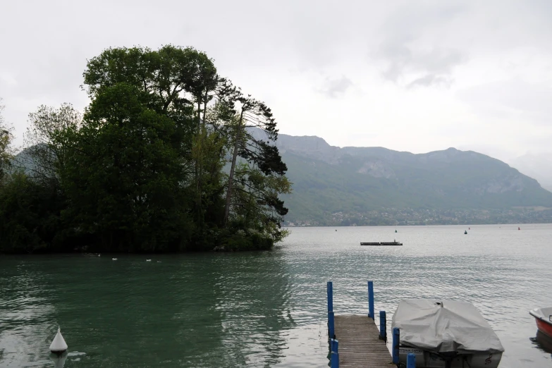 there are boats sitting on the water next to a pier