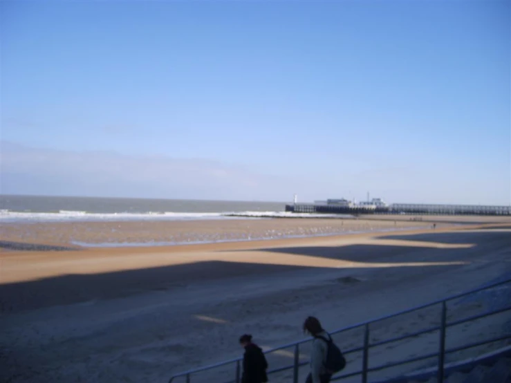 people walk up a stairway next to the ocean